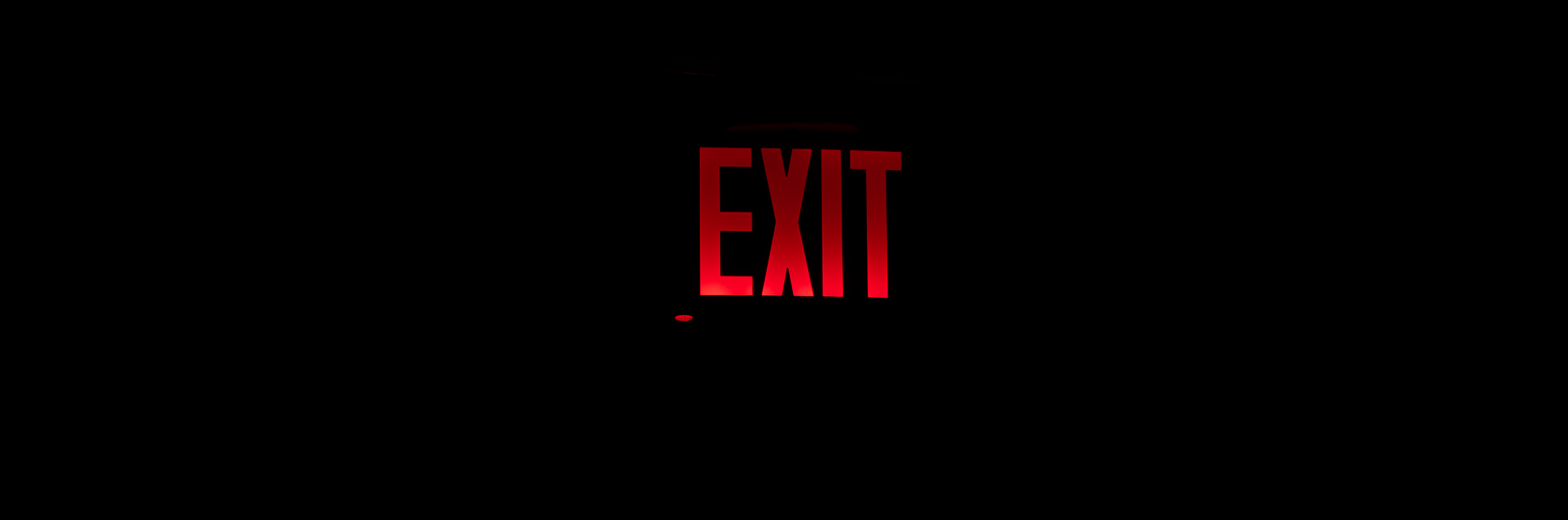 Red 'EXIT' sign on a black background